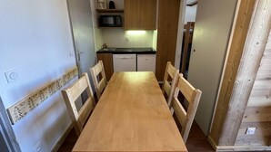 Une cuisine de taille réduite, dotée de meubles en bois, d’un four à micro-ondes et d’un lave-vaisselle.
