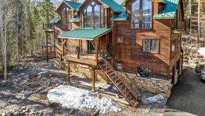 Eine Holzhütte mit einer Terrasse, umgeben von Bäumen.
