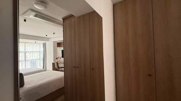 Un dormitorio con una cama, un armario de madera y una ventana con cortinas.