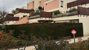 En bostadsbyggnad med ett platt tak, en grind vid ingången och en skylt som visar att tillträdet är begränsat.