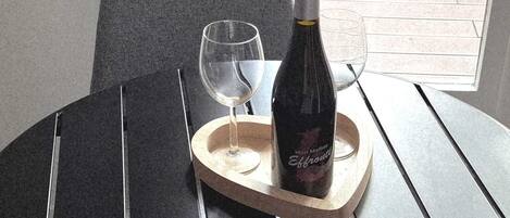 A table with a bottle of wine and two glasses on a tray.