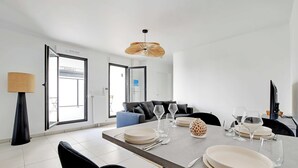 Een moderne eetruimte met een tafel voor vier personen, een bank en een groot raam.