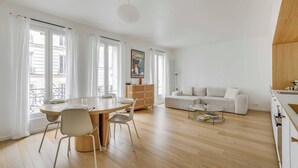 A modern living space with a dining area, a sofa, and a kitchen. - Beautiful Apartment - 1br- 4P - Sacre-coeur (Paris)