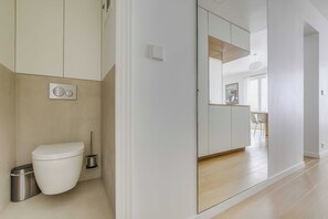 Ein modernes Badezimmer mit Toilette, Bidet und Mülleimer.