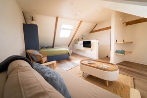 A loft-style bedroom with a bed, a TV, a sofa, and a coffee table. - The Loft by Cornish Wave, Central Newquay (Newquay)