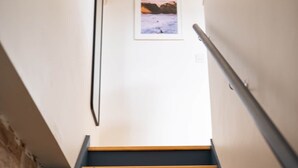 A staircase with wooden steps and a black handrail. - Surf Loft Steps From The Beach (Newquay)