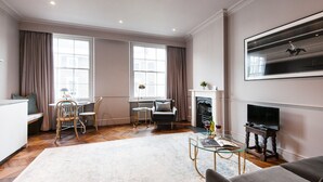 A spacious living room with a fireplace, a dining area with a table and chairs, and a sofa. - The Cleveland Arms II (London)