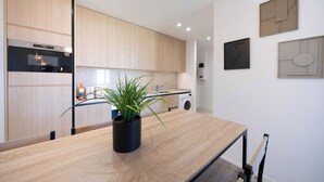 A modern kitchen with wooden cabinets, a built-in oven, a sink, and a countertop with a potted plant. - Charming Apartment - 2bdr/6p - Saint Tropez/port (Saint-Tropez)