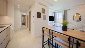 A modern kitchen with a dining area, a washing machine, and a potted plant. - Charming Apartment - 2bdr/6p - Saint Tropez/port (Saint-Tropez)