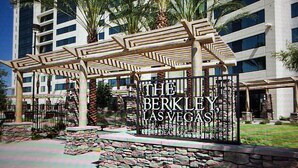 A hotel entrance with a stone wall, a pergola, and palm trees. - Resort with 1 bedroom and AC in delightful Las Vegas (Las Vegas)