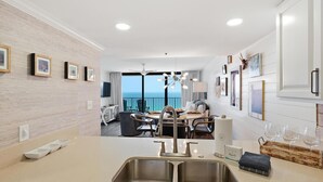 Une cuisine moderne dotée d’un grand îlot central, d’un coin repas offrant une vue agréable et d’un balcon avec vue.