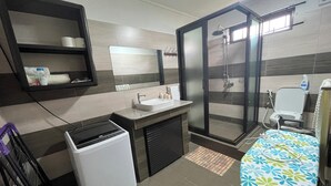 Ein modernes Badezimmer mit Dusche, Toilette und einem kleinen Waschbecken.