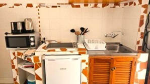Una cocina compacta equipada con microondas, tostadora y refrigerador.