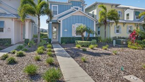 A residential neighborhood with houses featuring front yards, pathways, and small trees. - Waterfront 3BR Pool Cottage at Margaritaville Orlando - Near Disney (Kissimmee)