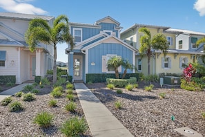 A residential neighborhood with houses featuring front yards, pathways, and small trees. - Waterfront 3BR Pool Cottage at Margaritaville Orlando - Near Disney (Kissimmee)