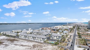 Eine Küstenstadt mit Strandhotels, einem Steg und wolkenlosem, blauem Himmel.