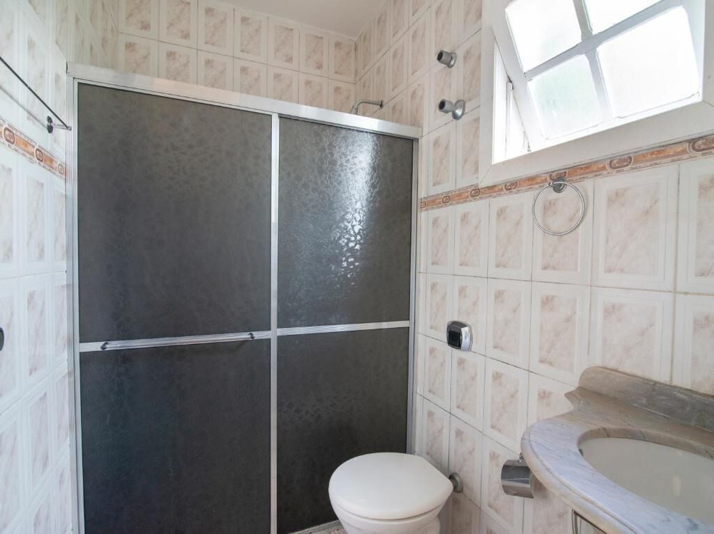 A bathroom with a shower, toilet, and sink.