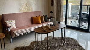 Una sala de estar moderna con sofá, mesa de centro y una alfombra mullida grande.