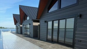 Un edificio moderno con ventanas amplias y una terraza de madera.