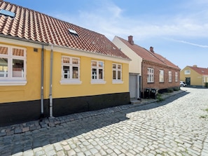 Mukulakivikatu, jonka varrella on kelta- ja punakattoisia rakennuksia.