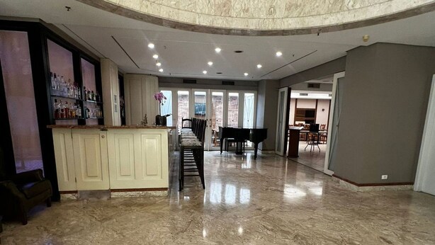 A spacious lobby with a marble floor, a piano, a reception desk, and a staircase leading to an upper level. - Flat em Moema com Cozinha (São Paulo)