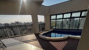 A rooftop terrace with a swimming pool, tiled flooring, and a view of the cityscape. - Flat em Moema com Cozinha (São Paulo)