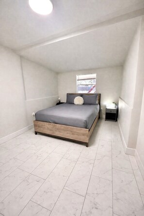 A bedroom with a bed, a nightstand, a window, and a ceiling light. - 2-bedroom private home in the center of Miami with cool AC for relaxing stays (Miami)