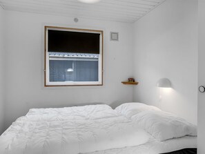 A bedroom with a bed, a window, a wall-mounted shelf, and a wall lamp. - "Jytte" - 800m to the fjord by Interhome (Roslev)