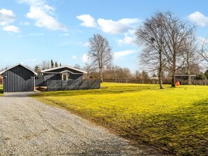 Ein Anwesen auf dem Land mit einem Schotterweg, einem Stall und einem eingezäunten Feld.