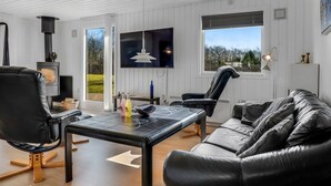 A modern living room with a fireplace, leather furniture, a flat-screen TV, and large windows. - "Jytte" - 800m to the fjord by Interhome (Roslev)
