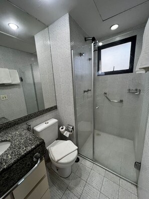 Une salle de bain moderne avec une douche à parois de verre, des toilettes et un comptoir en granit.