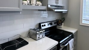 Een keuken met witte kastjes, een ingebouwde oven, een broodrooster en een bordje met 'Home' boven de kastjes.