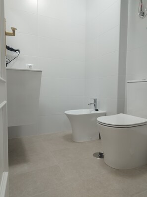 Een haardroger, handdoeken, zeep, toiletpapier