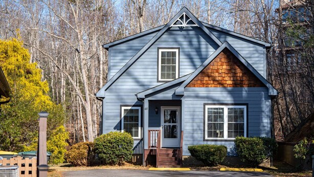 A two-story house with a gabled roof, a front porch, and a brick section on the right side. - Mountain View Retreat Near Downtown AVL! (Asheville)