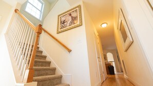 A staircase with a wooden handrail, carpeted steps, and a picture on the wall. - Mountain View Retreat Near Downtown AVL! (Asheville)
