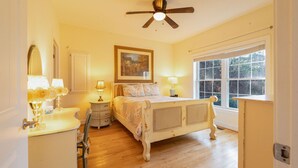 A bedroom with a bed, bedside lamps, a dresser, a mirror, and a window with a view of trees. - Mountain View Retreat Near Downtown AVL! (Asheville)