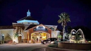 A hotel with a sign reading 'Regal Palms,' a fountain, and a palm tree. - 4Bd 3Ba, (2 Primary), 8.7m to Disney, No Resort Fees! (Davenport)