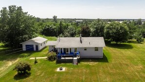 A single-story house with a front porch, a small shed, and a well-maintained lawn.