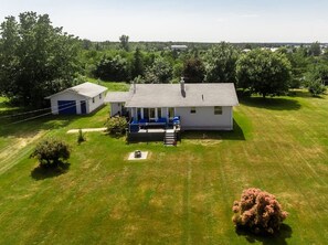 A single-story house with a front porch, a small shed, and a well-maintained lawn.