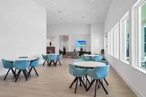 A spacious conference room with modern furniture, a flat-screen TV, and large windows. - The Enchanted ReTreat by Disney (Davenport)