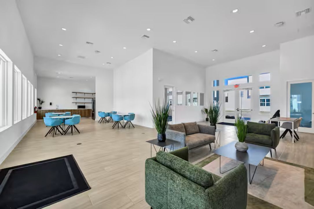 Eine geräumige, moderne Hotelhalle mit Essbereich, Sitzgelegenheiten und einer Rezeption.