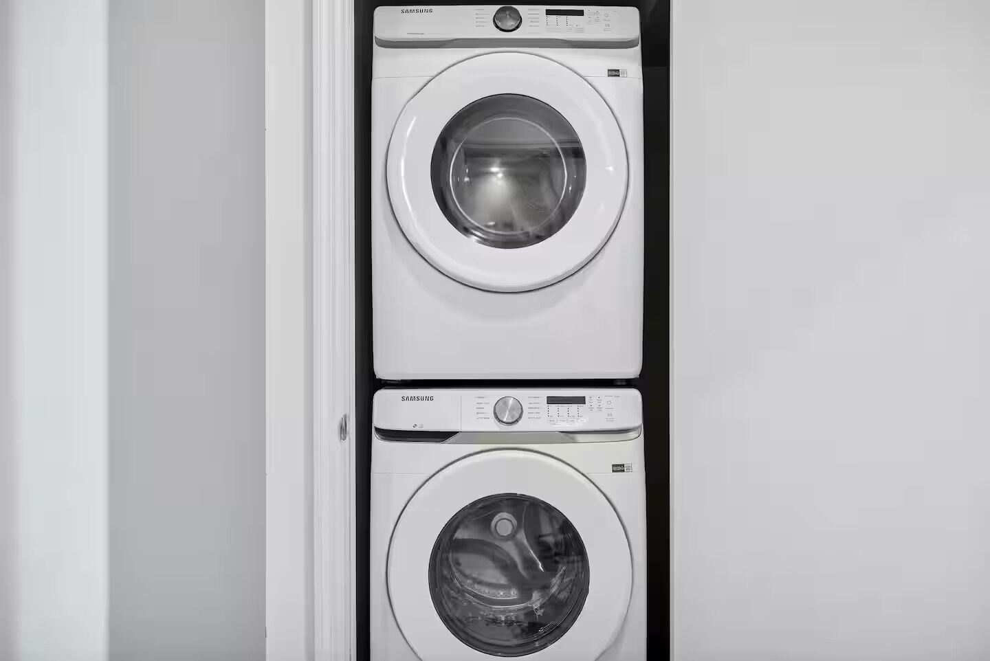 Una lavadora y secadora empotradas en la pared, con un panel de control y una pantalla digital.