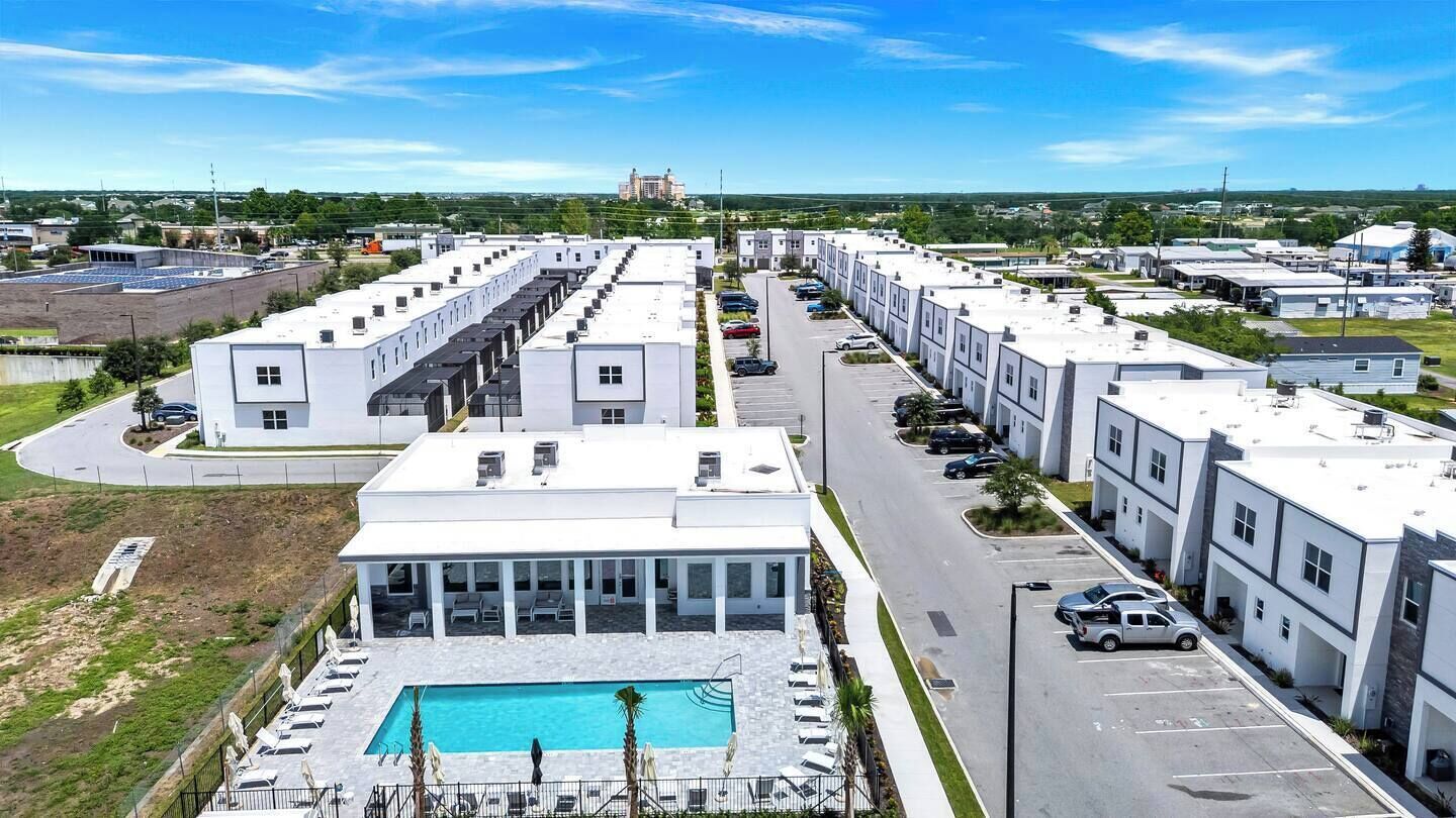 Ein modernes Hotel mit Pool, mehreren Parkplätzen und Blick auf die Umgebung.