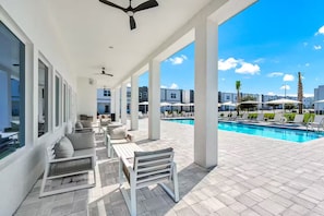 Ein überdachter Außenbereich mit Pool, Sitzgelegenheiten und Blick auf die umliegenden Gebäude.