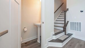 A staircase with wooden steps and a handrail, leading to an upper floor. - Coastal Townhome with 2 Pools & Gym (Berlin)
