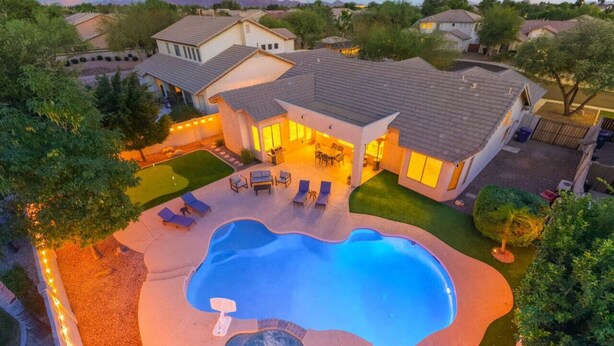 Ein Wohnhaus mit Swimmingpool, Whirlpool und Sitzgelegenheit im Freien.