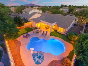 A residential property with a swimming pool, hot tub, and outdoor seating area. - The Thirsty Cactus | Heated Pool, Spa & Games (Chandler)