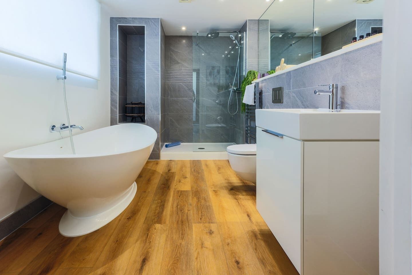 Ein modernes Badezimmer mit einer freistehenden Badewanne, einer begehbaren Glasdusche und einer Toilette.