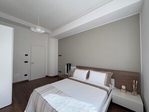 Ein Schlafzimmer mit Bett, Nachttisch und einer Tür.