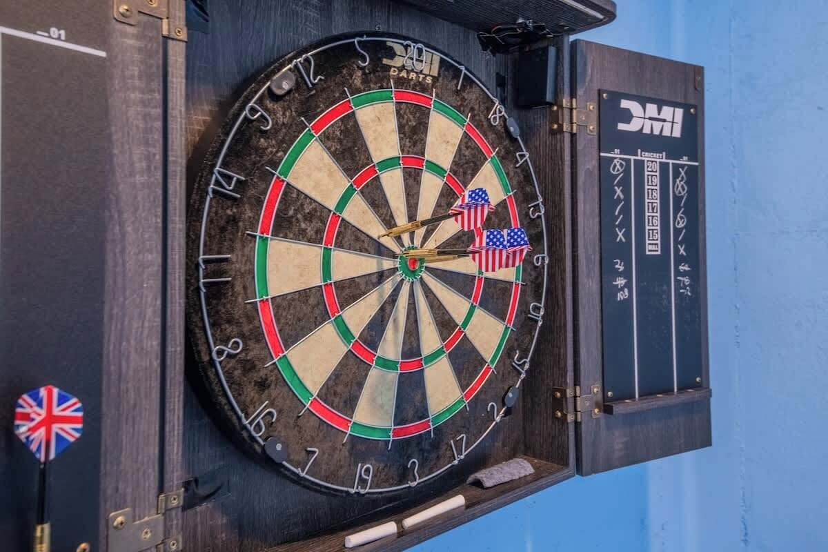 A dartboard with American flags and a scoreboard.